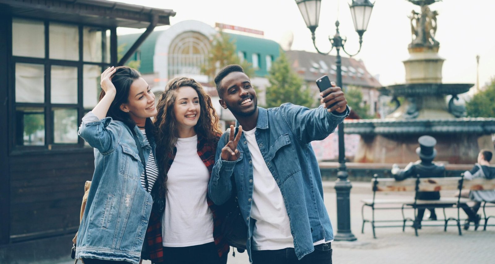 Gruppe von Freunden, die gemeinsam auf einer belebten Straße in einer Stadt ein Selfie aufnehmen