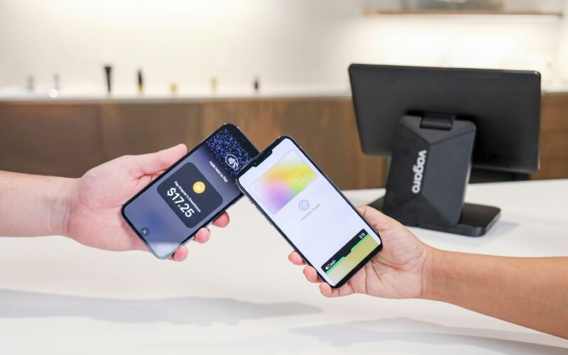 Zwei Smartphones werden genutzt, um eine kontaktlose Zahlung zwischen Geräten durchzuführen. Modernes mobiles Bezahlen im Alltag.