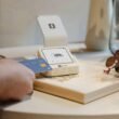 Eine Hand hält eine Kreditkarte und nutzt sie für eine digitale Zahlung an einem Lesegerät.