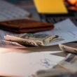 Mehrere Geldscheine und wichtige Unterlagen liegen ordentlich auf einem Schreibtisch im Büro, bereit zur Bearbeitung.