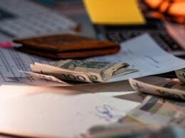 Mehrere Geldscheine und wichtige Unterlagen liegen ordentlich auf einem Schreibtisch im Büro, bereit zur Bearbeitung.