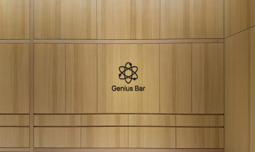 Genius Bar Logo auf einer hellen Holzpaneelwand – modernes Branding in technisch gestalteter Umgebung