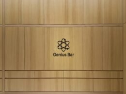 Genius Bar Logo auf einer hellen Holzpaneelwand – modernes Branding in technisch gestalteter Umgebung