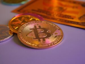 Goldene Bitcoin-Münze neben weiteren Münzen und einer Kreditkarte, Symbol für Kryptowährungen und digitales Bezahlen