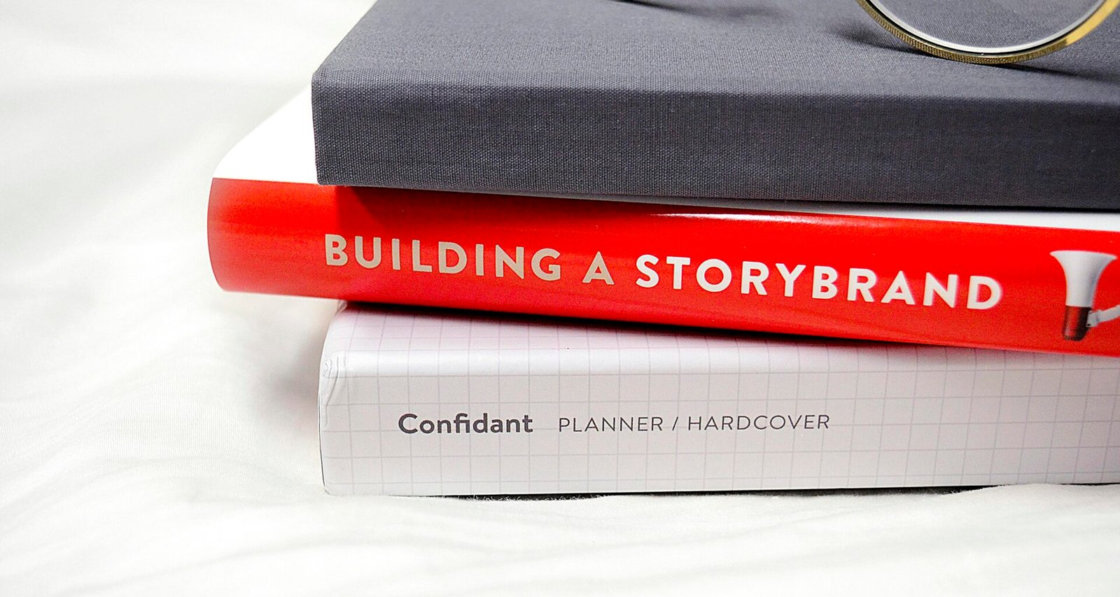 Eine goldene Brille liegt auf einem schwarzen Hardcover-Buch. Das Bild vermittelt einen eleganten, minimalistischen Arbeitsstil.