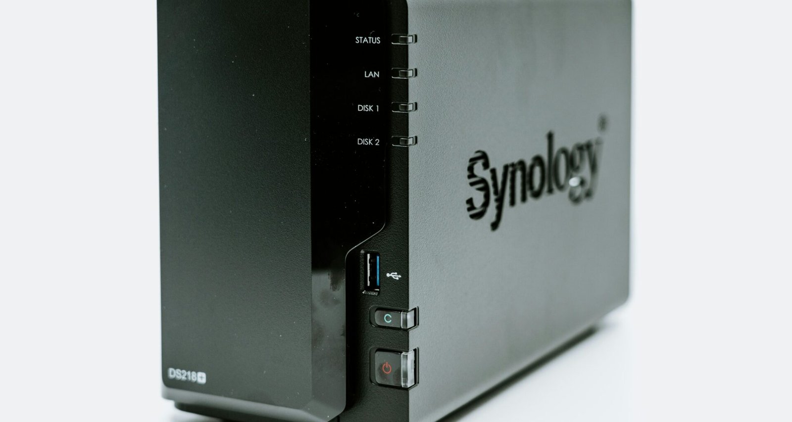 Ein graues Synology NAS-Gerät mit mehreren Einschüben, fotografiert aus der Nähe, zur Darstellung moderner Speicherlösungen.