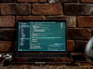 Eingeschalteter grauer Laptop auf einem Tisch, bereit für den Einsatz im Büro oder Homeoffice, Bildschirm ist sichtbar