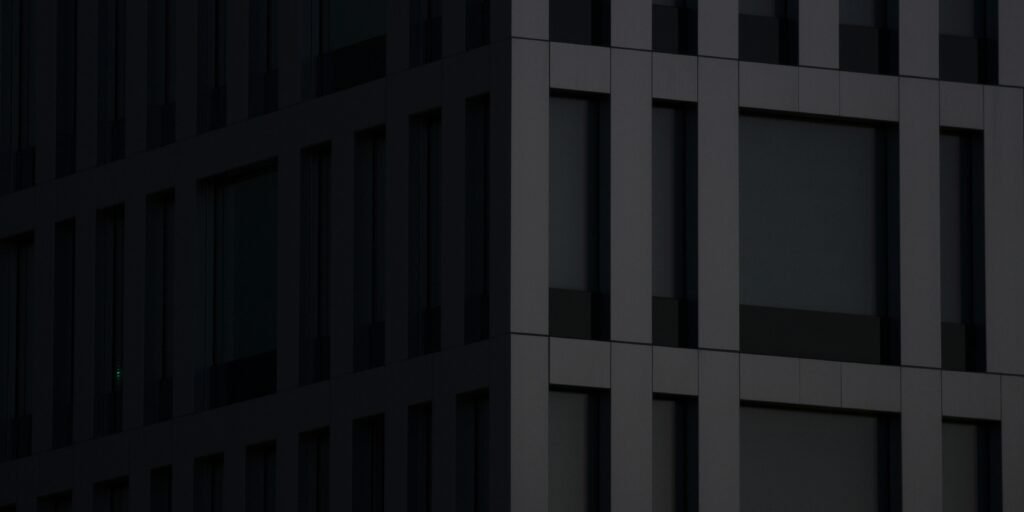 Modernes graues Betongebäude bei Tageslicht mit klaren Linien und minimalistischer Fassade in urbaner Umgebung