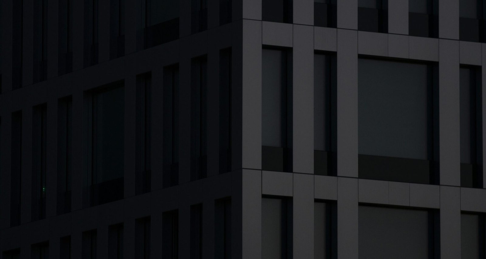 Modernes graues Betongebäude bei Tageslicht mit klaren Linien und minimalistischer Fassade in urbaner Umgebung