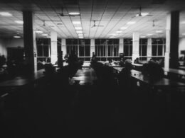 Grayscale-Foto eines modernen Raumes mit mehreren Tischen, geeignet für Meetings oder Gruppenarbeit