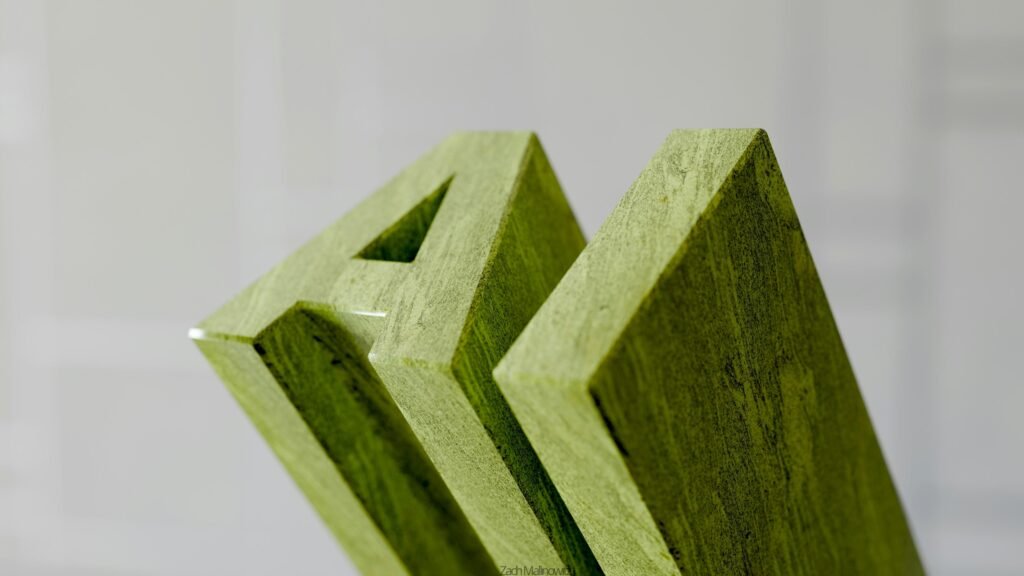 Nahaufnahme von grünen Holzbuchstaben, die das Wort „am“ auf heller Oberfläche anordnen