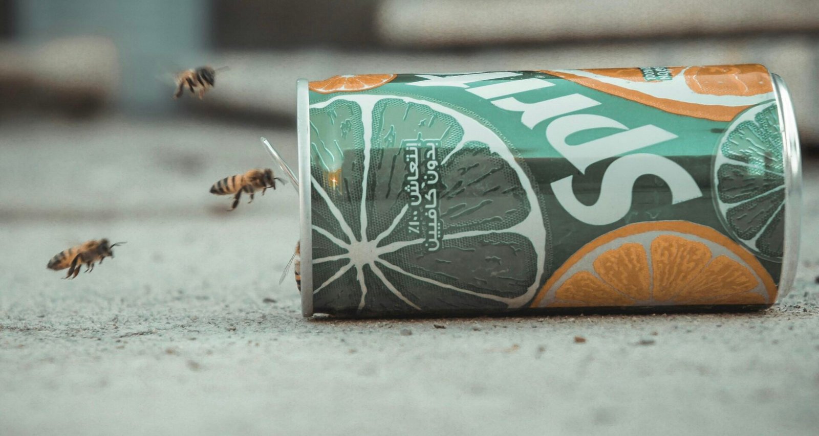 Eine grüne und orangefarbene Sprite-Dose steht aufrecht vor neutralem Hintergrund, klar im Fokus und detailliert abgebildet.