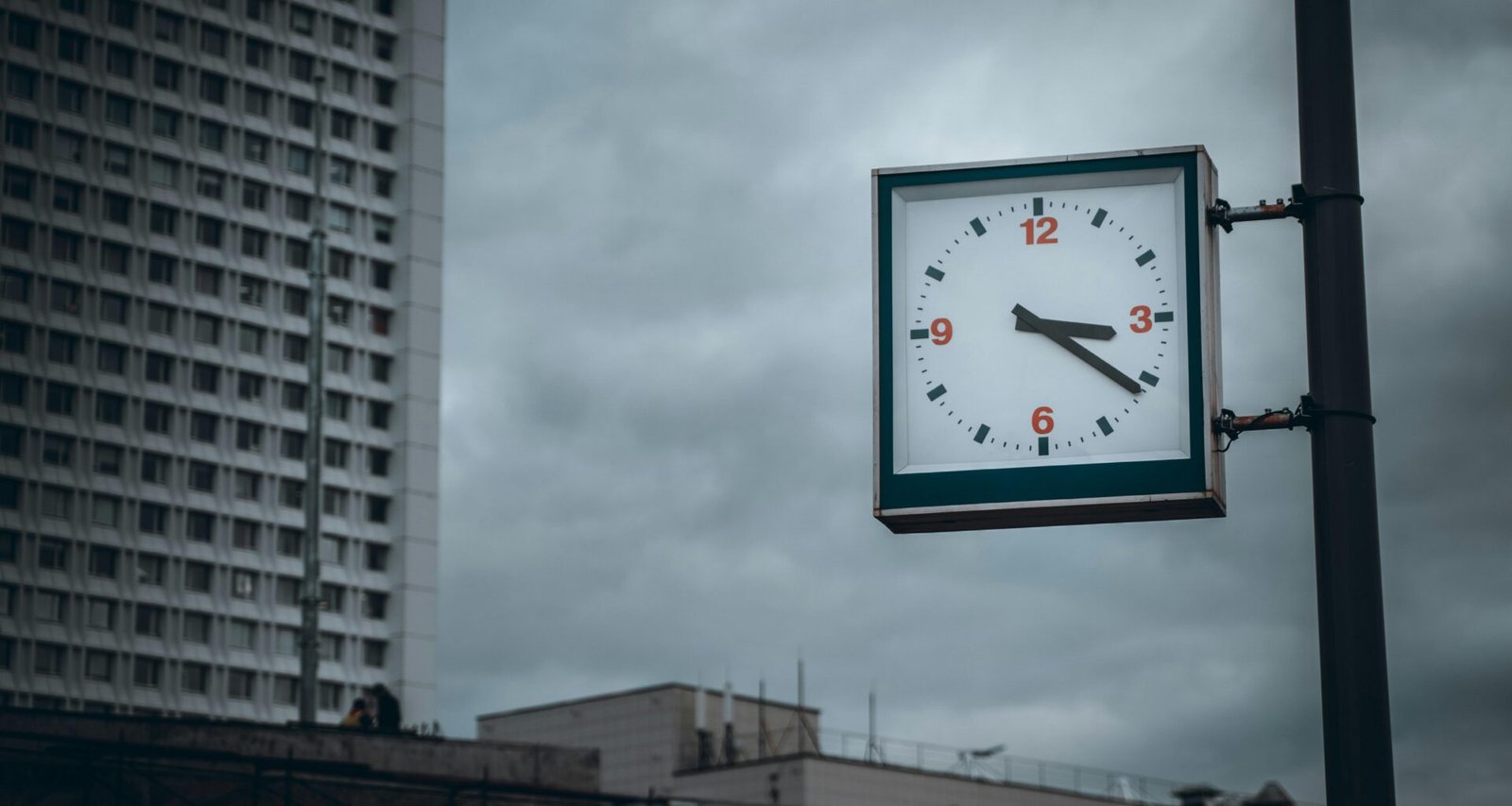 Grüne und weiße analoge Wanduhr auf heller Fläche mit Zeigern auf 10:00 Uhr, Nahaufnahme.