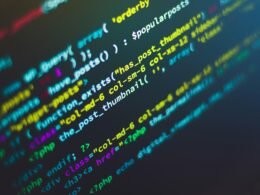 Computerbildschirm mit grünem, blauem und gelbem Text, der Codezeilen oder Programmiersprache darstellt