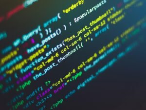 Computerbildschirm mit grünem, blauem und gelbem Text, der Codezeilen oder Programmiersprache darstellt
