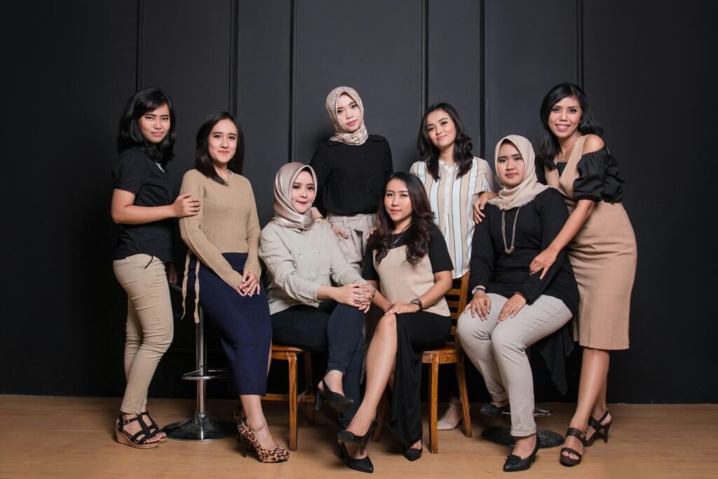 Mehrere Frauen sitzen gemeinsam in einer modernen Büroumgebung auf Stühlen für eine Teambesprechung.