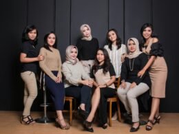 Mehrere Frauen sitzen gemeinsam in einer modernen Büroumgebung auf Stühlen für eine Teambesprechung.