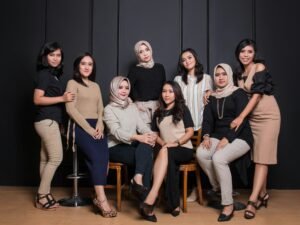 Mehrere Frauen sitzen gemeinsam in einer modernen Büroumgebung auf Stühlen für eine Teambesprechung.