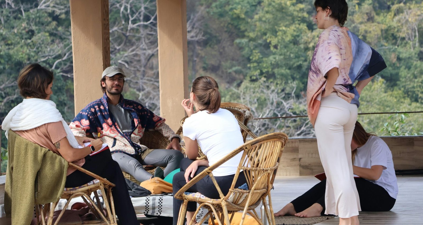 Mehrere Personen sitzen entspannt zusammen auf einer überdachten Veranda und genießen die gemeinsame Zeit im Freien