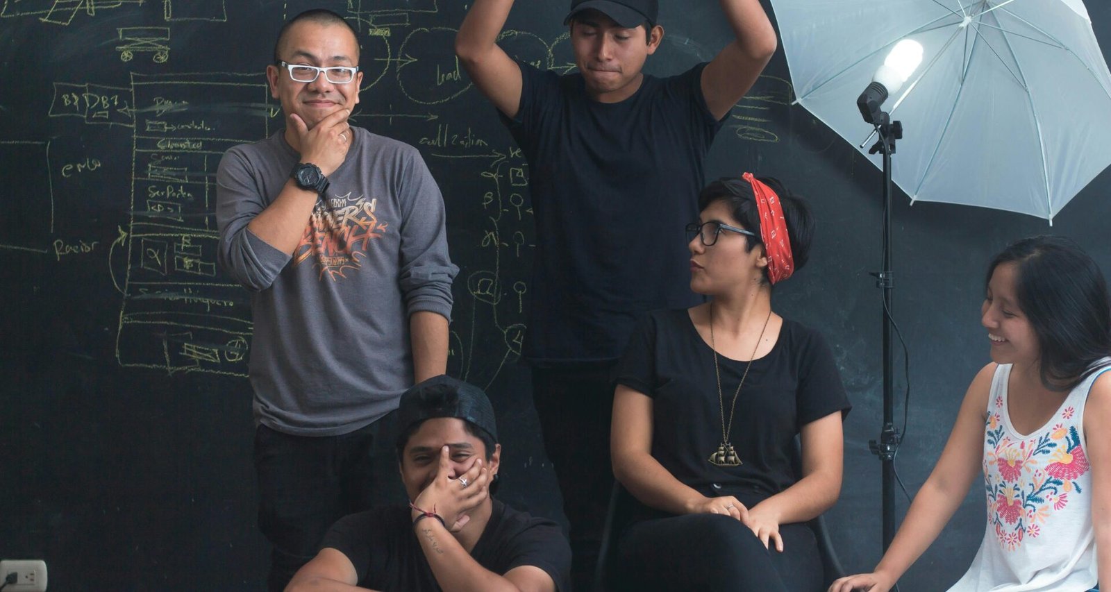 Mehrere Personen arbeiten gemeinsam in einem modernen Studio mit Tischen, Laptops und Notizbüchern