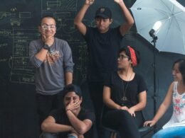 Mehrere Personen arbeiten gemeinsam in einem modernen Studio mit Tischen, Laptops und Notizbüchern