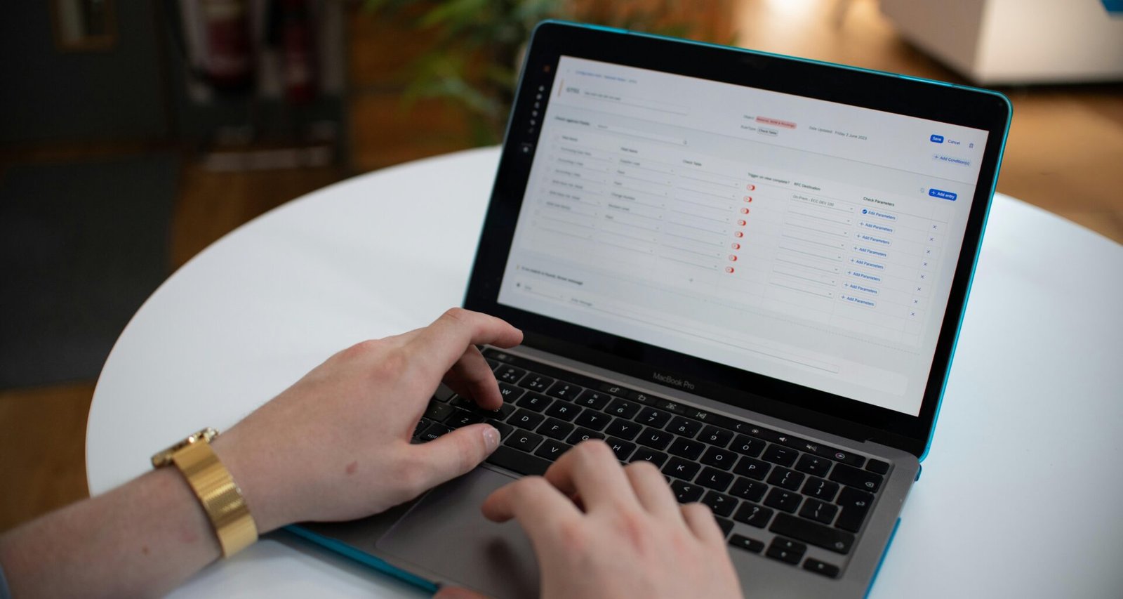 Hände tippen auf einer Laptop-Tastatur, auf dem Bildschirm ist ein Spreadsheet geöffnet und sichtbar
