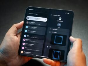 Zwei Hände halten ein aufklappbares Smartphone, das auf dem Bildschirm das Menü Einstellungen anzeigt.