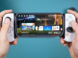 Zwei Hände halten ein Smartphone mit aufgestecktem Gamecontroller und zeigen modernes mobiles Gaming.