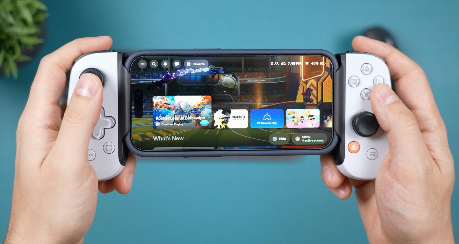 Hände halten ein Smartphone mit einem Gamecontroller-Aufsatz, der das mobile Spielen erleichtert.