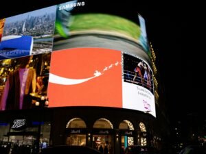 Leuchtende Werbetafeln erhellen eine nächtliche Straße in der Großstadt mit moderner, digitaler Werbung