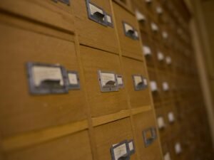 Holz-Karteischrank mit vielen Schubladen und klar beschrifteten Etiketten, ideal zur strukturierten Datenorganisation