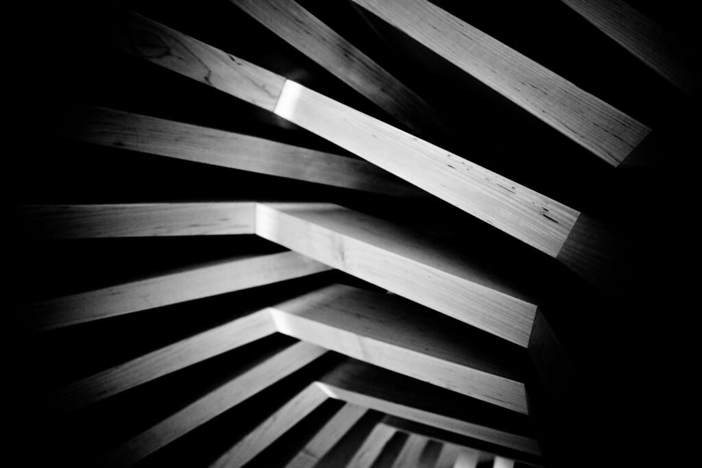 Geometrisch angeordnete Holzplanken mit ausgeprägtem Schattenwurf für ein modernes Designkonzept