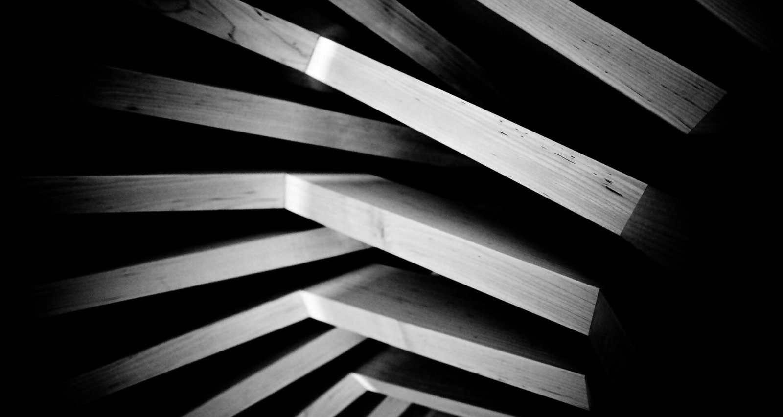 Geometrisch angeordnete Holzplanken mit ausgeprägtem Schattenwurf für ein modernes Designkonzept