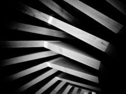 Geometrisch angeordnete Holzplanken mit ausgeprägtem Schattenwurf für ein modernes Designkonzept