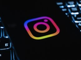 Instagram-Logo auf dunklem Hintergrund, beleuchtet von einer Computertastatur mit bunten Lichtern, Symbol für digitale Vernetzung