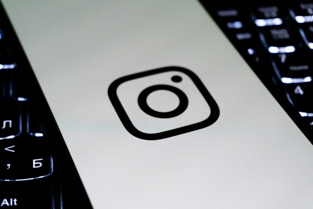 Instagram Logo auf weißer Fläche mit Tastatur im Hintergrund – Sinnbild für digitale Social Media Nutzung im Arbeitsalltag.