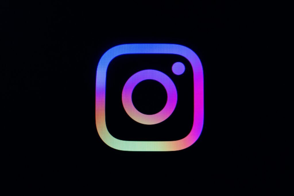 Instagram Logo mit farbigem Verlauf auf schwarzem Hintergrund, Darstellung des bekannten Social-Media-Icons
