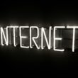 Leuchtender Neon-Schriftzug mit dem Wort 'Internet' an einer Wand, Symbol für digitale Welt und moderne Technologien