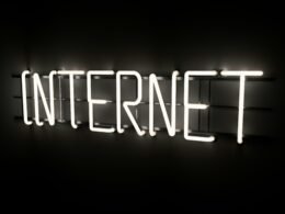 Leuchtender Neon-Schriftzug mit dem Wort 'Internet' an einer Wand, Symbol für digitale Welt und moderne Technologien