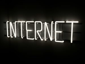 Leuchtender Neon-Schriftzug mit dem Wort 'Internet' an einer Wand, Symbol für digitale Welt und moderne Technologien