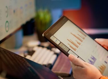 Eine Person prüft und analysiert Finanzdaten auf einem Tablet, moderne digitale Auswertung im Detail sichtbar