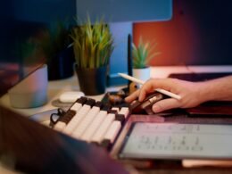 Person arbeitet konzentriert am Computer und benutzt eine Maus auf einem modernen Arbeitsplatz