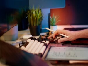 Person arbeitet konzentriert am Computer und nutzt eine Maus, typische Szene im modernen Büroalltag