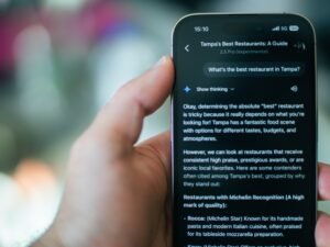 Person sucht mit dem Smartphone nach einem Restaurant und nutzt dabei eine Karten- oder Bewertungs-App