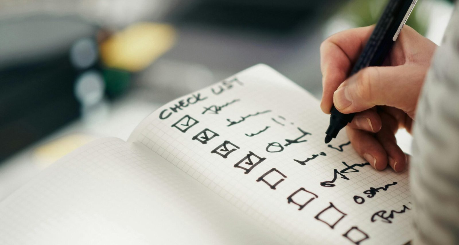 Person markiert einzelne Aufgaben auf einer Checkliste, ideales Bild für Themen rund um Aufgabenplanung und Organisation.