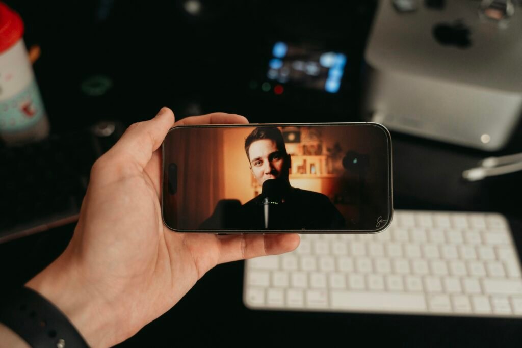 Eine Person hält ein Smartphone in der Hand und sieht sich ein Video auf dem Bildschirm an.