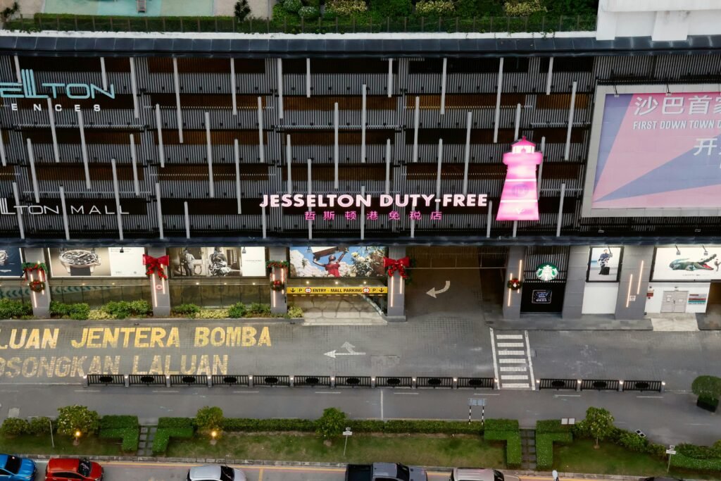 Das Jesselton Duty-Free-Gebäude mit farbenfrohen Schildern und moderner Fassade, fotografiert von You Le