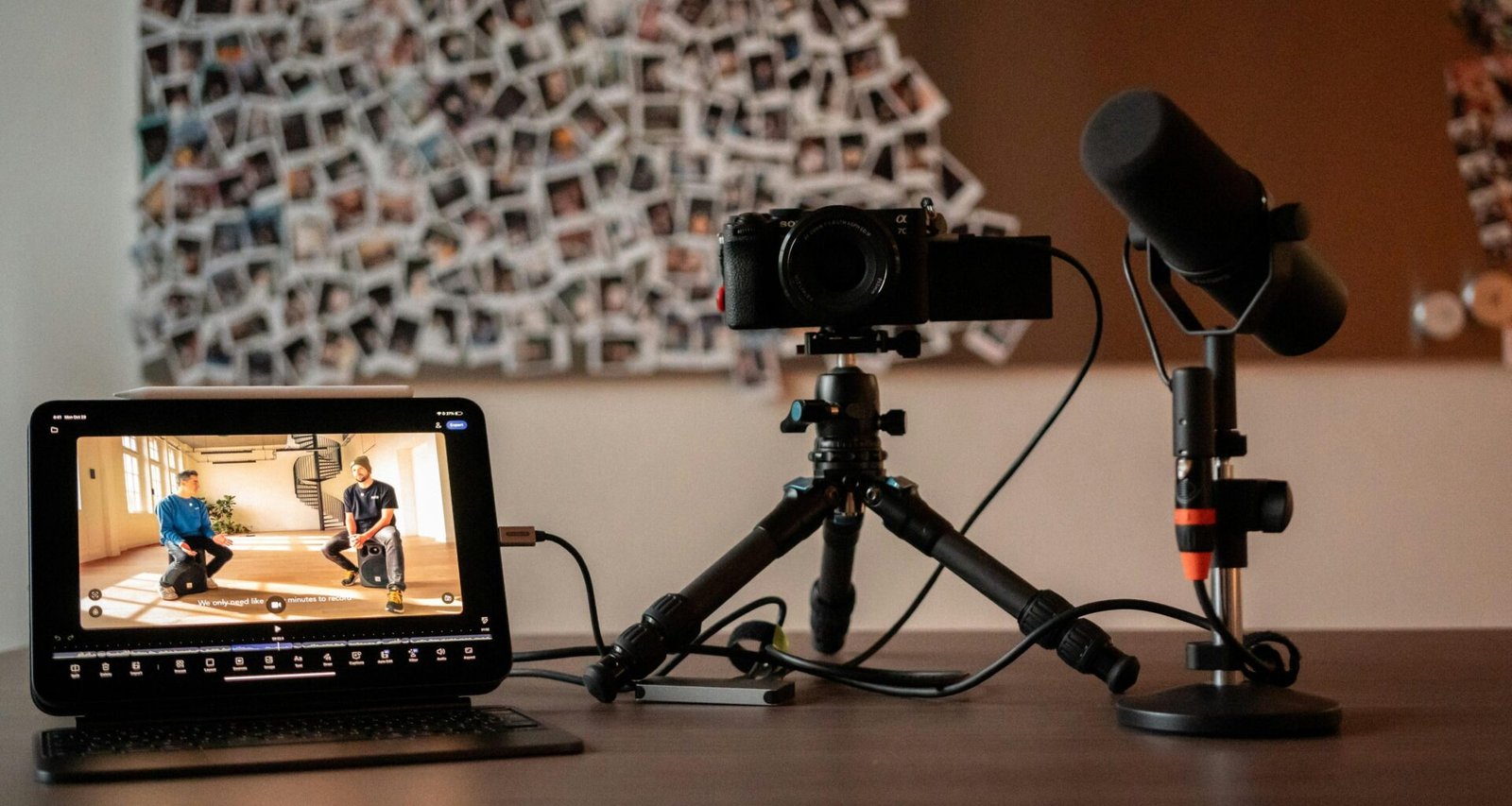 Kamera, Mikrofon und Monitor auf einem Schreibtisch mit minimalistischer Einrichtung für professionelle Content-Erstellung