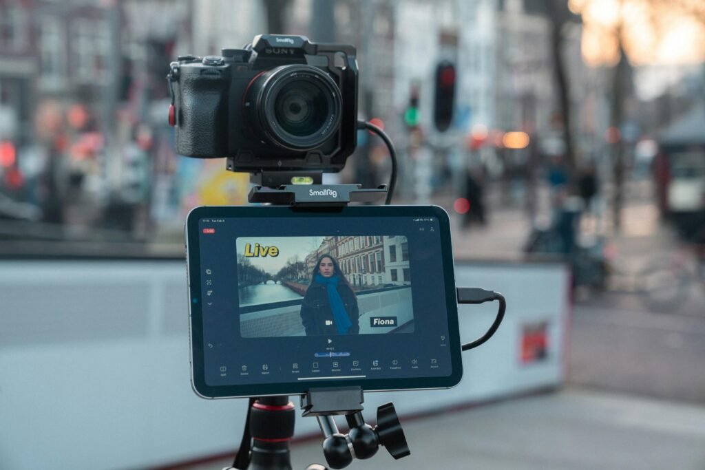 Kamera und Tablet montiert auf einem Stativ filmen eine städtische Straße im urbanen Umfeld bei Tageslicht.