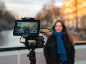 Kamera-Setup auf einem Stativ mit Frau im Hintergrund nahe einem Kanal, Fokus auf Technik und kreative Arbeit